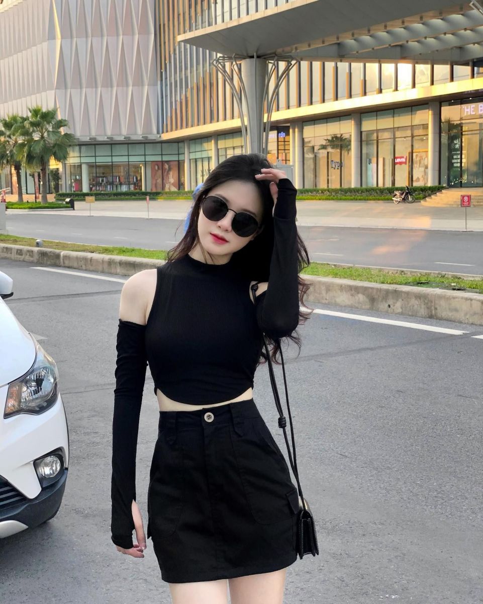 Cô gái trẻ mặc áo thun đen và chân váy đen giữa phố