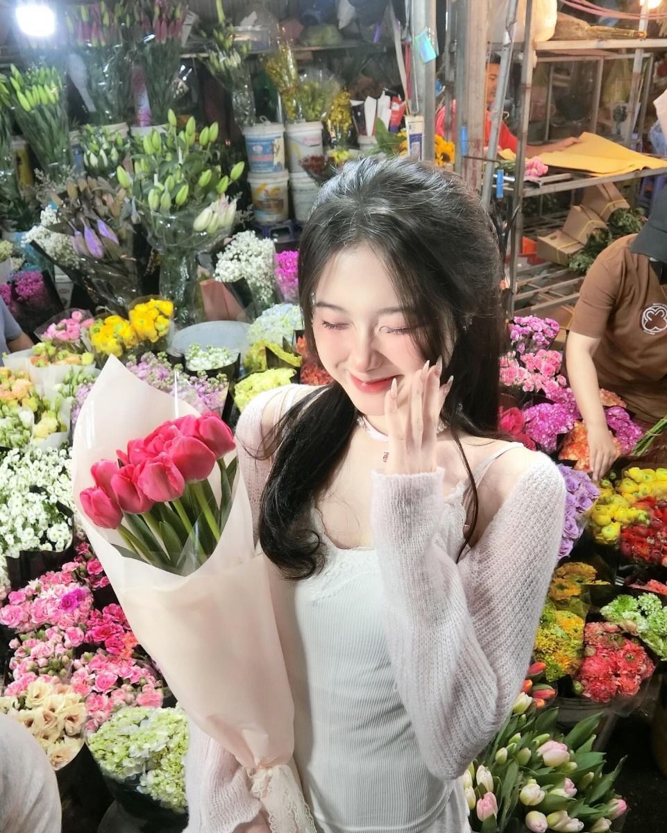 Cô gái trẻ mặc áo thun trắng và áo khoác len mỏng