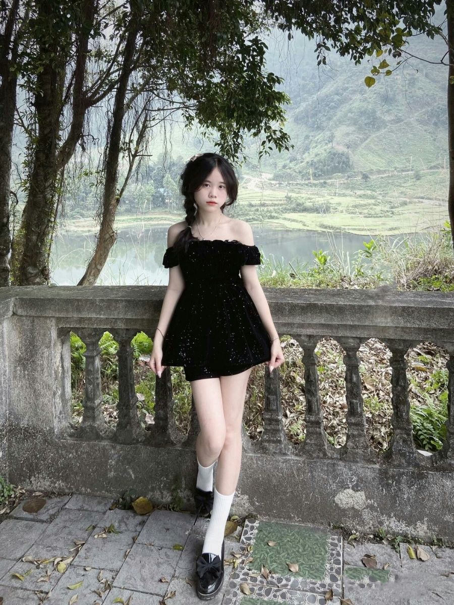 Cô gái trẻ mặc đầm đen bên lan can thơ mộng