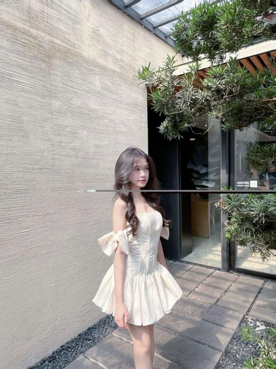 Cô gái trẻ mặc đầm trắng bên ngôi nhà hiện đại