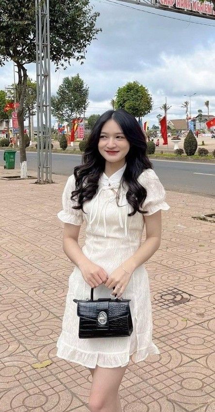 Cô gái trẻ mặc đầm trắng nhẹ nhàng trên phố Tây