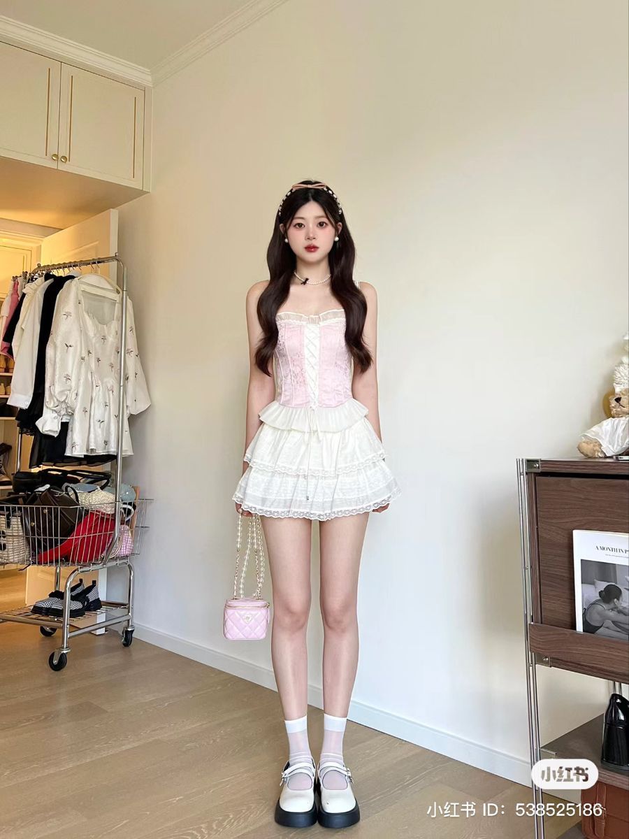 Cô gái trẻ mặc trang phục trắng với chi tiết hồng trong căn phòng sang trọng