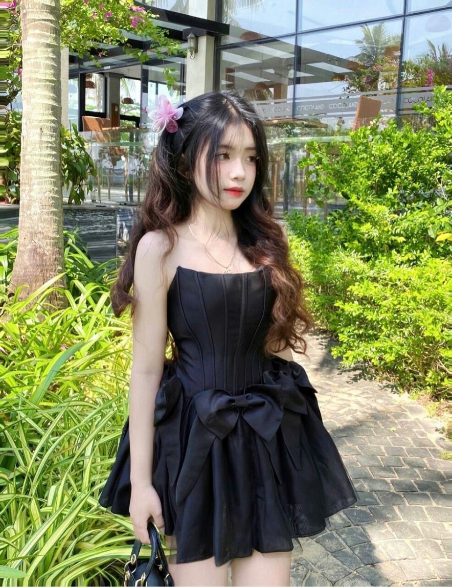 Cô gái trẻ mặc váy ngắn giữa khu vườn xanh mát