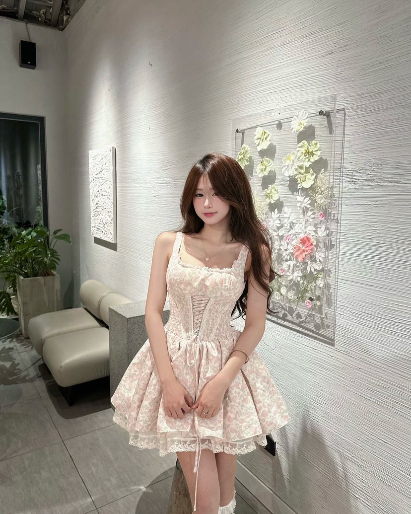 Cô gái trẻ mặc váy ngắn màu hồng họa tiết hoa trong không gian hiện đại