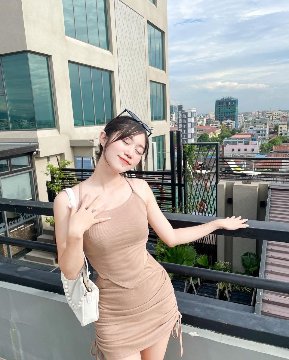 Cô gái trẻ mặc váy ôm màu nâu sáng trên sân thương mại
