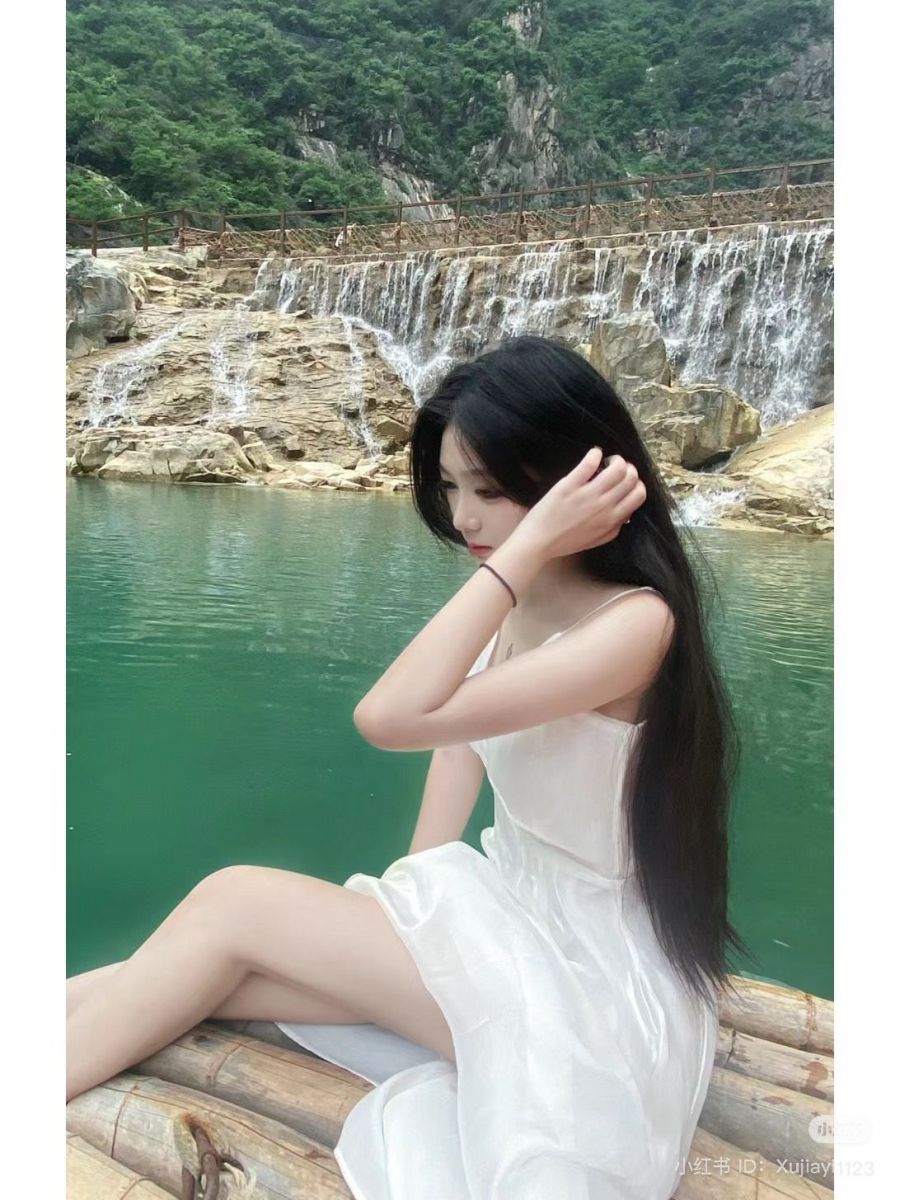 Cô gái trẻ mặc váy trắng bên bờ hồ Tây
