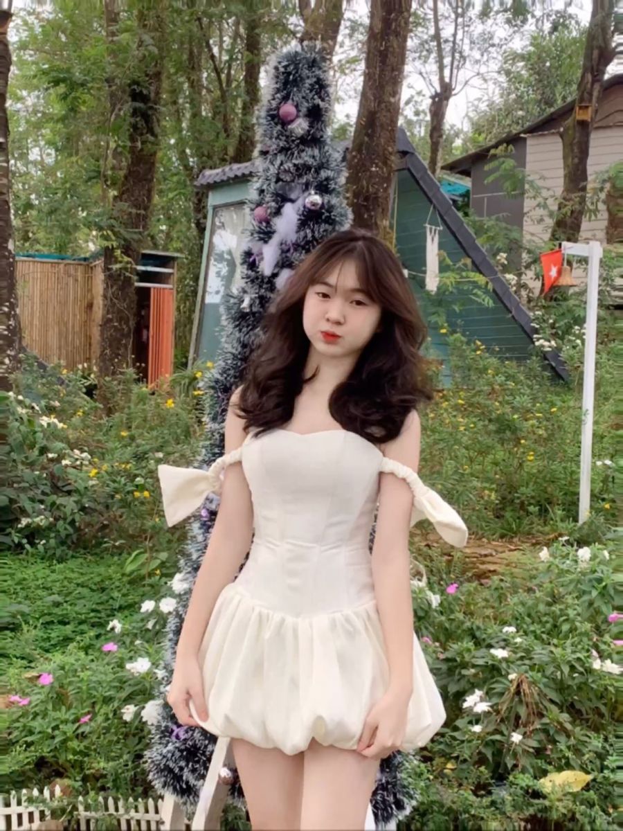 Cô gái trẻ mặc váy trắng tươi vui giữa rừng cây