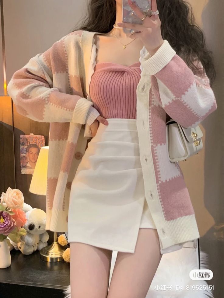 Cô gái trẻ trong áo khoác cardigan hồng và chân váy trắng ngắn