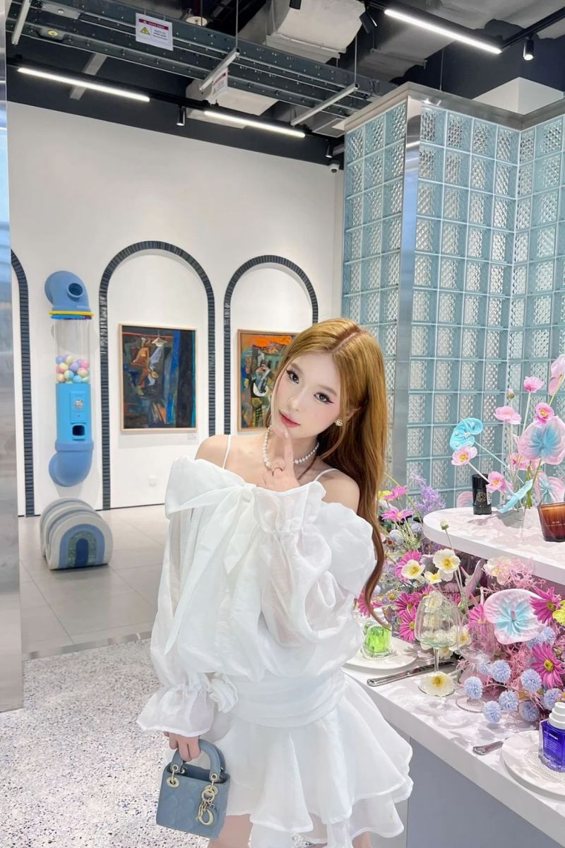 Cô gái trẻ trong áo trắng và chân váy xòe đầy sức sống