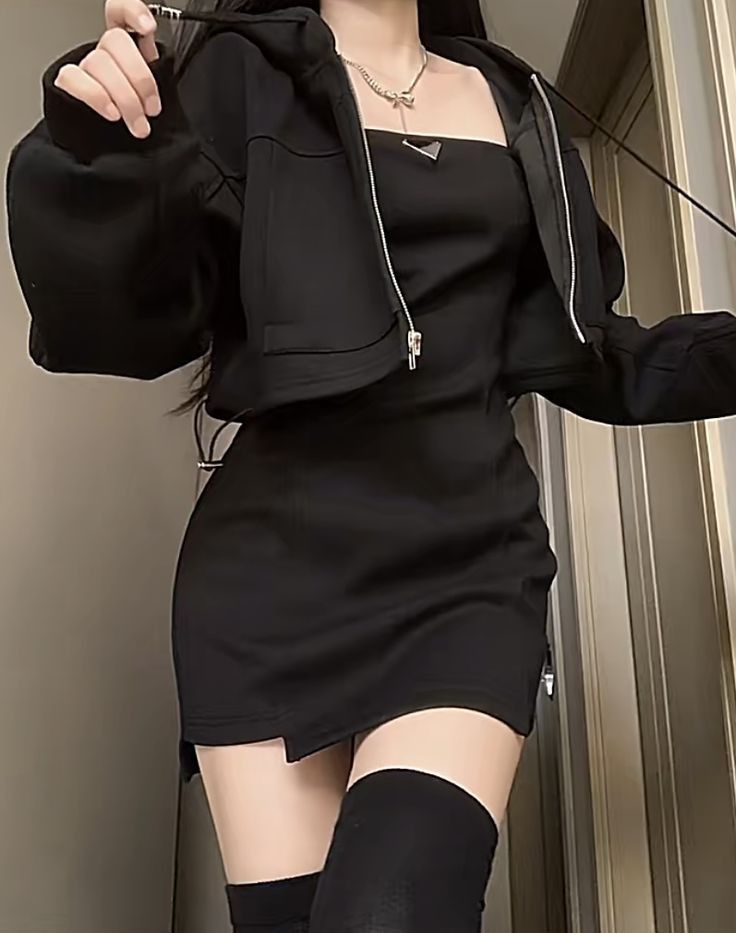 Cô gái trẻ trong chiếc váy đen với áo hoodie đen