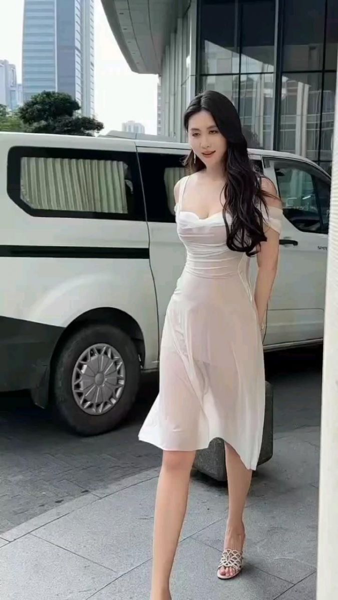 Cô gái trẻ tự tin trong váy trắng trên phố