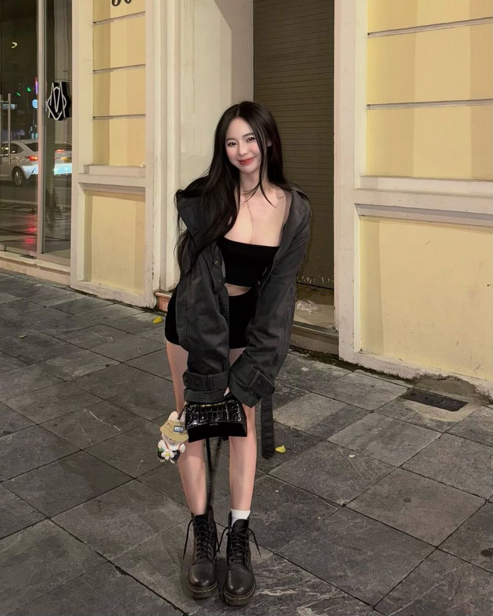 Cô gái trẻ tự tin với áo khoác đen và áo crop top trên phố