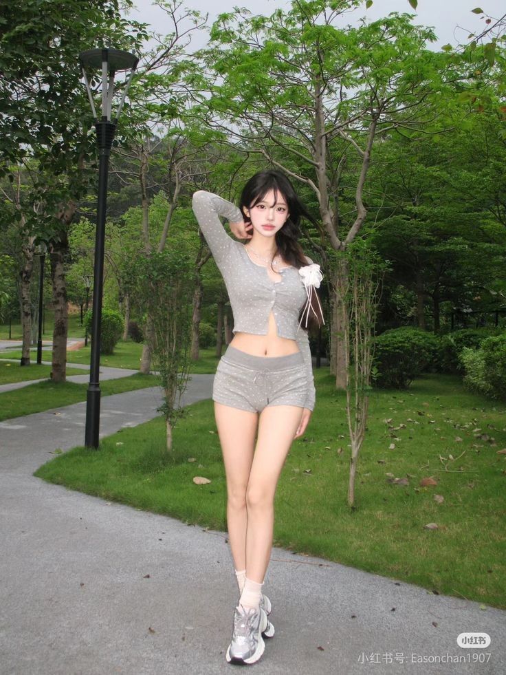 Cô gái trẻ với áo crop top và quần shorts thể thao màu xám