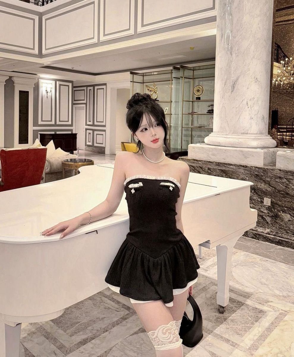 Cô gái trẻ xinh đẹp bên cây đàn piano trắng
