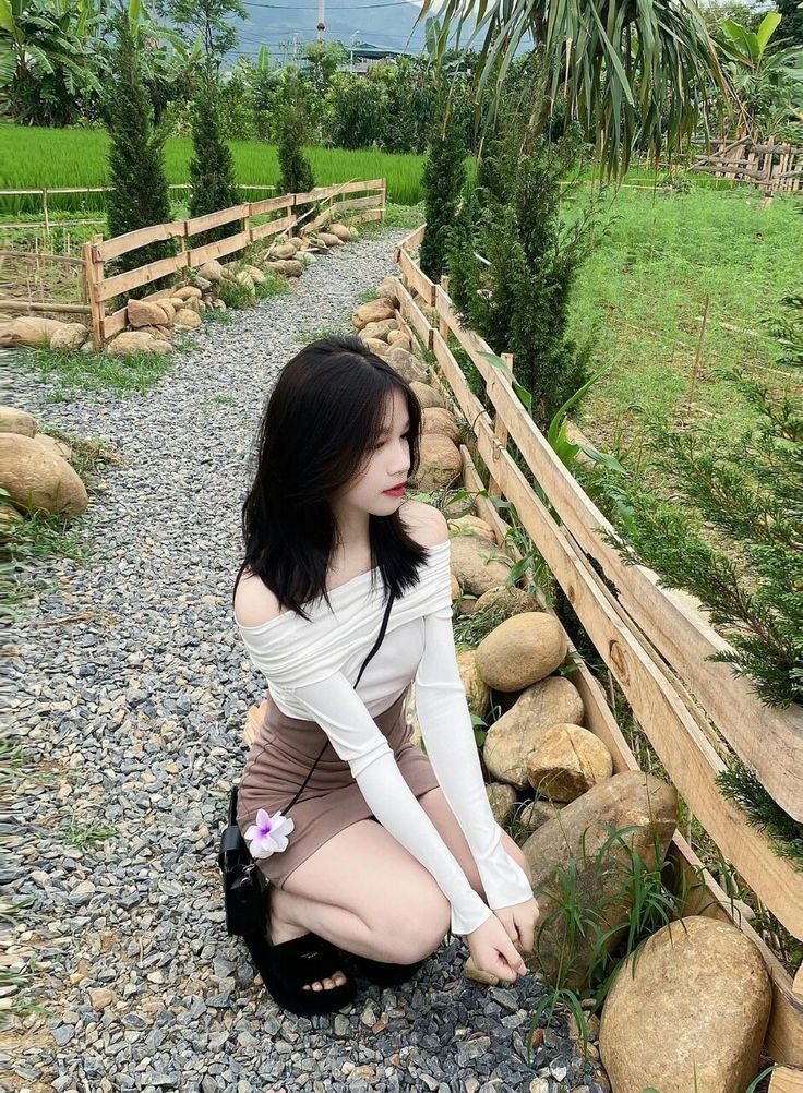 Cô gái trẻ xinh đẹp mặc áo dài trắng và chân váy nâu