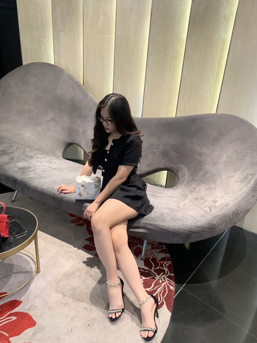 Cô gái trẻ xinh đẹp ngồi trên ghế sofa sang trọng