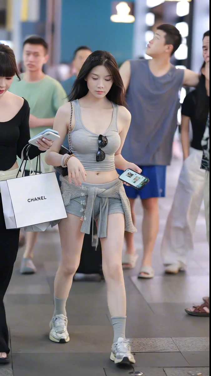 Cô gái trẻ xinh đẹp trong áo croptop xám và quần short