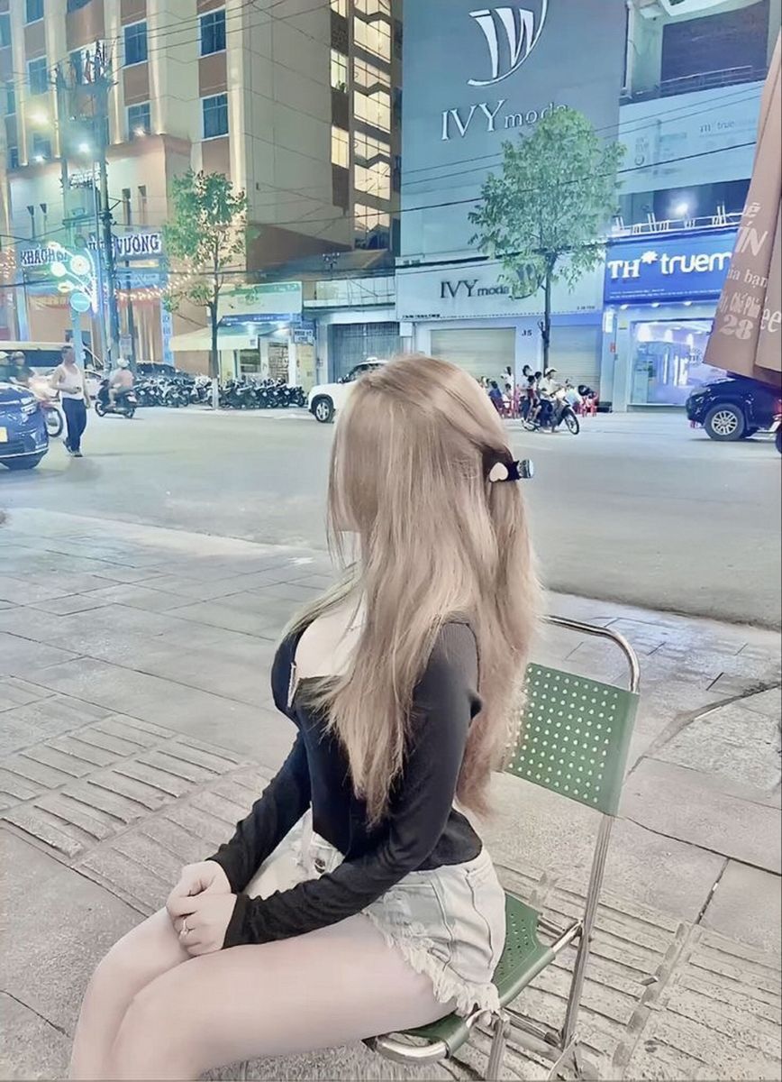 Cô gái trẻ xinh đẹp trong áo dài trắng và quần short