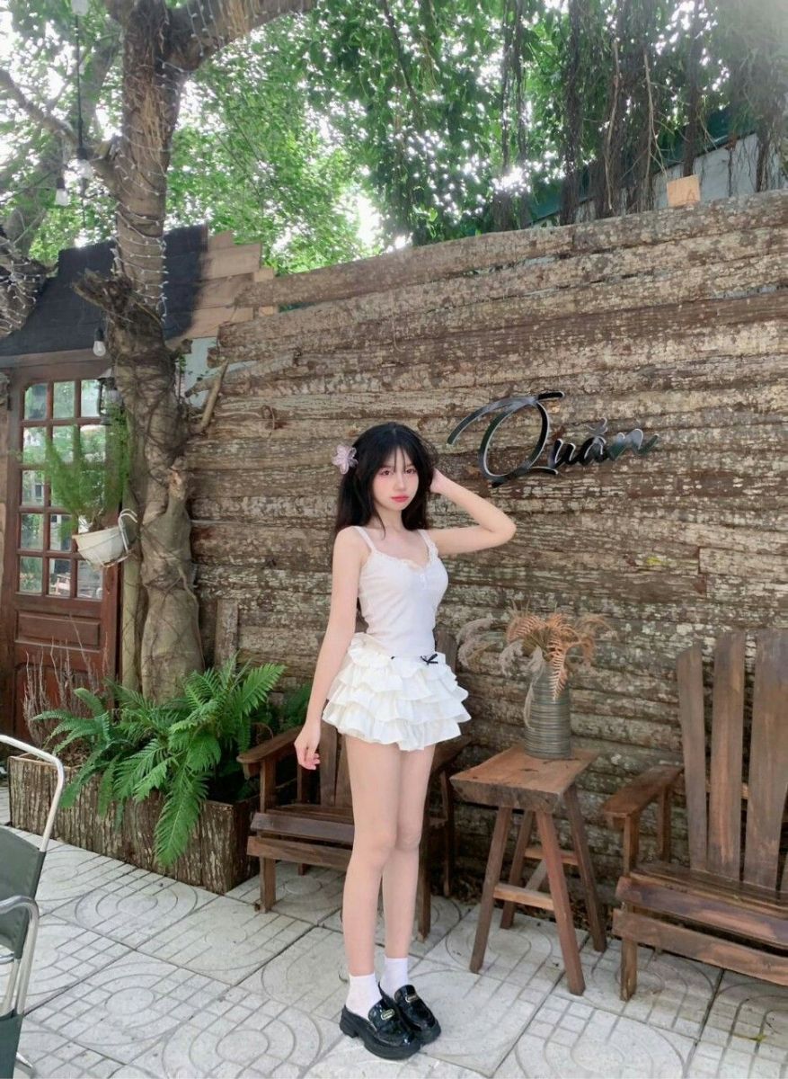 Cô gái trẻ xinh đẹp trong áo hai dây trắng nổi bật