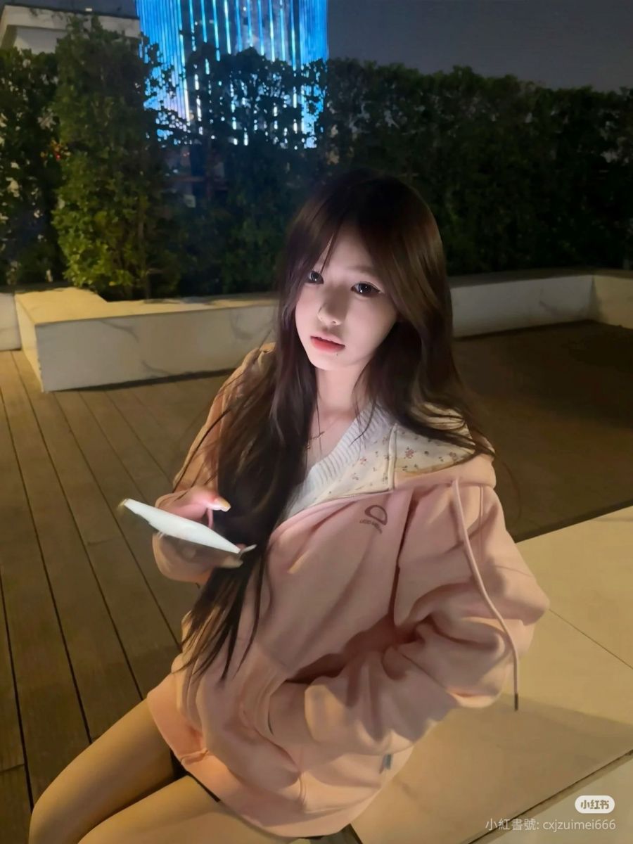 Cô gái trẻ xinh đẹp trong áo hoodie hồng ngoài trời