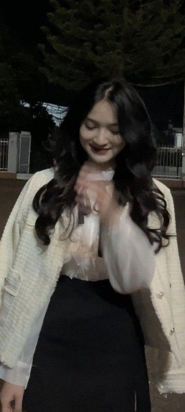 Cô gái trẻ xinh đẹp trong áo khoác trắng và blouse sang trọng