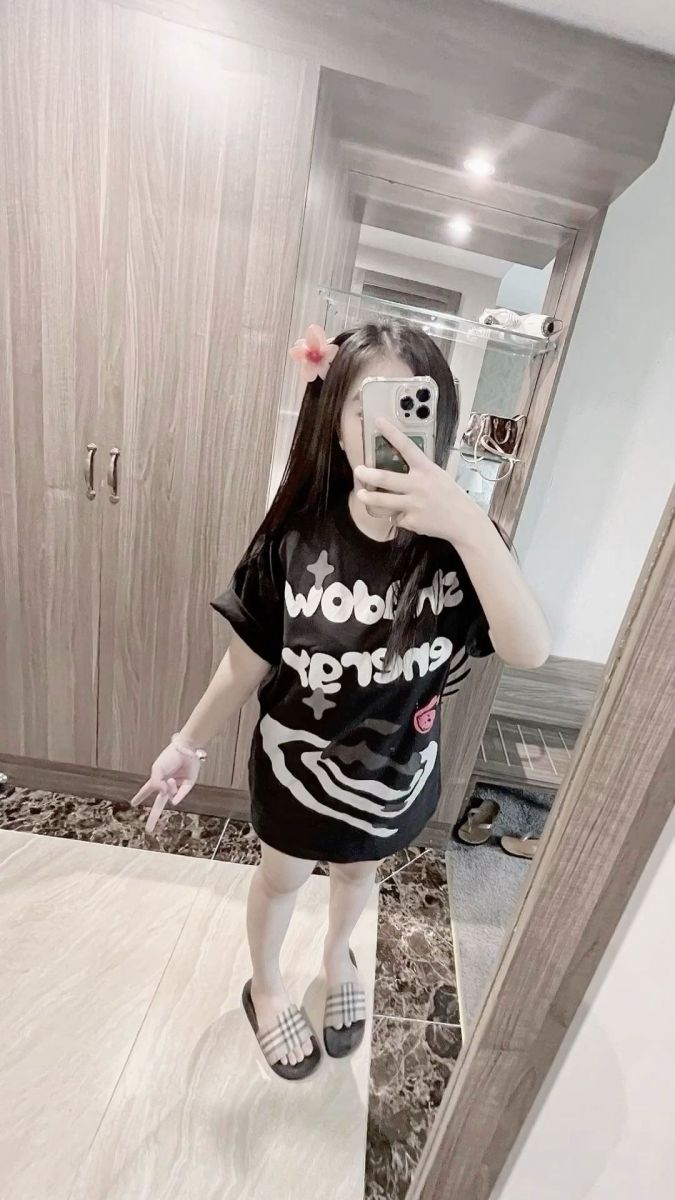 Cô gái trẻ xinh đẹp trong áo phông đen tạo dáng selfie vui vẻ