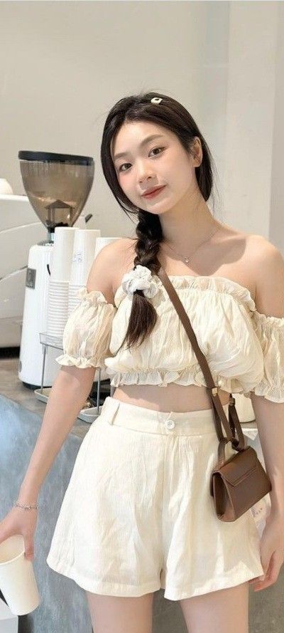 Cô gái trẻ xinh đẹp trong blouse hở vai và quần sọc