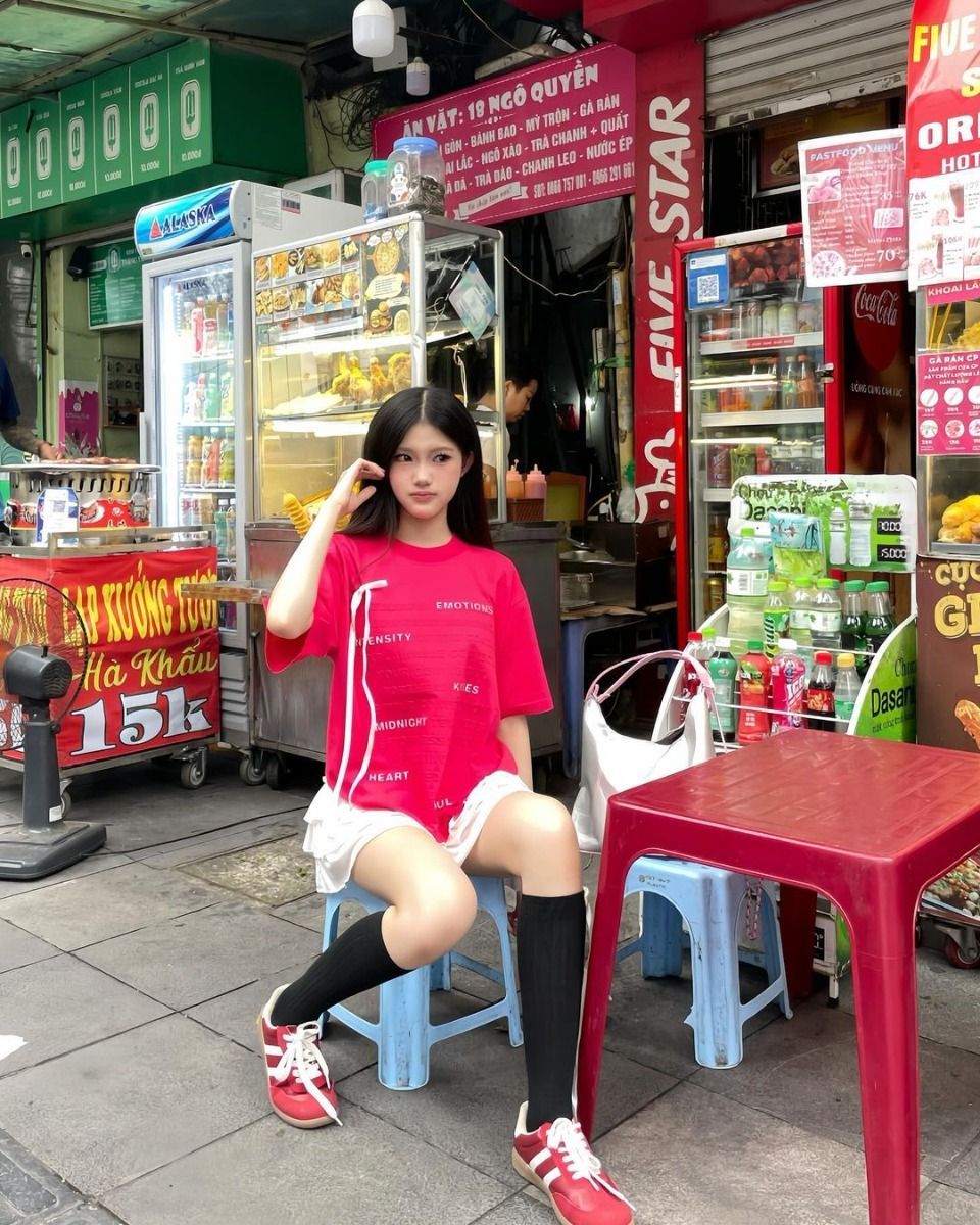Cô gái trẻ xinh đẹp trong bộ đồ phong cách tại quán ăn