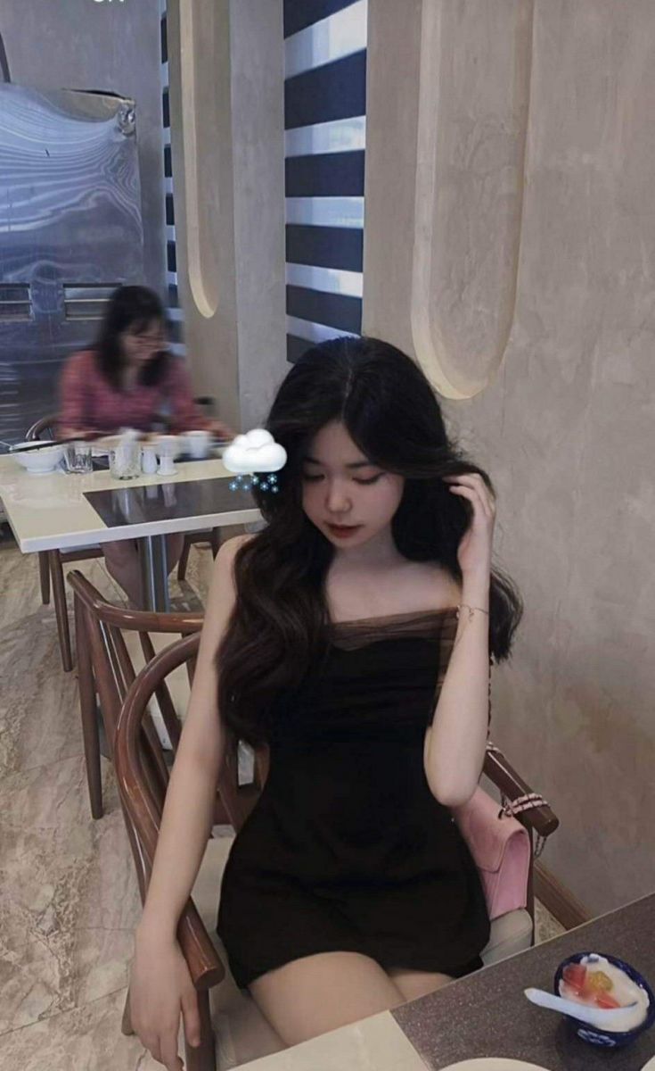 Cô gái trẻ xinh đẹp trong bộ váy trắng tại nhà hàng sang trọng
