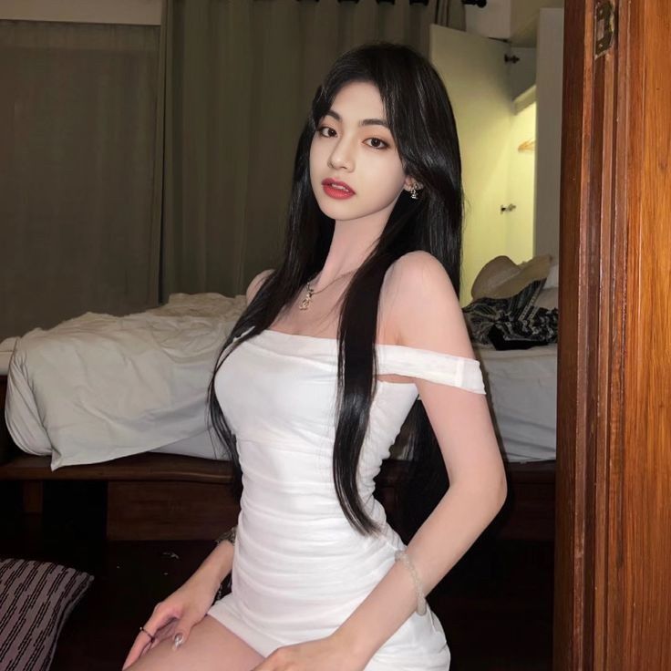 Cô gái trẻ xinh đẹp trong chiếc váy trắng ngồi trên ghế