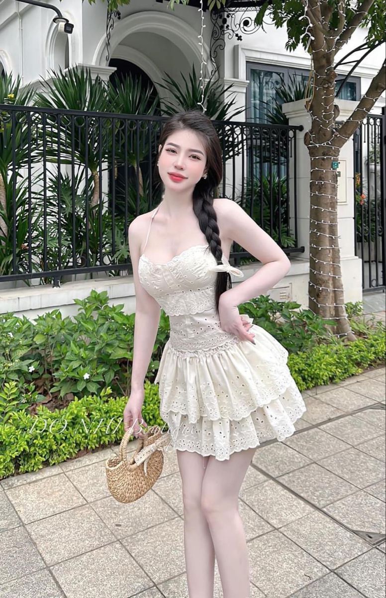 Cô gái trẻ xinh đẹp trong đầm trắng nổi bật cùng chiếc gió xinh xắn