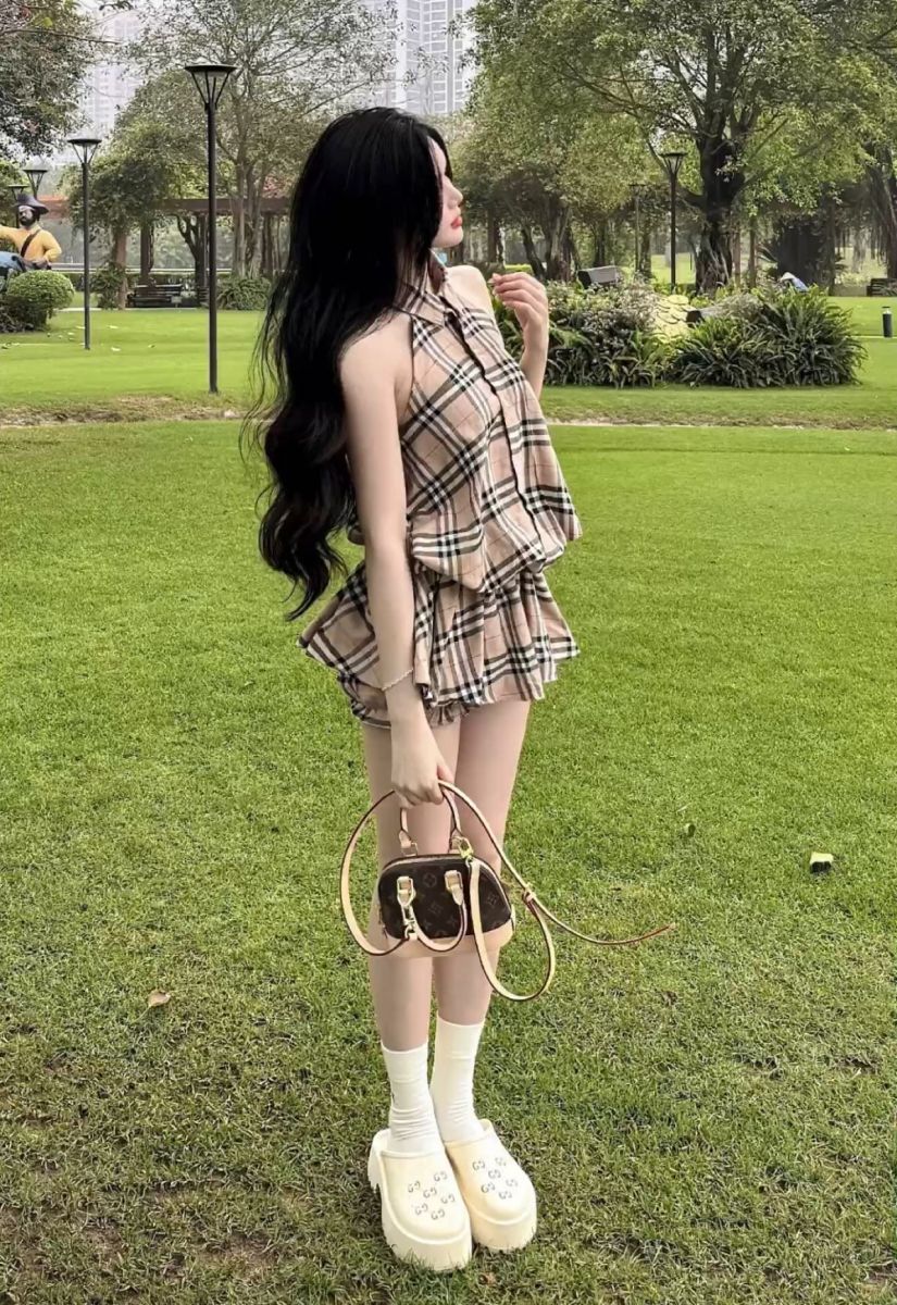 Cô gái trẻ xinh đẹp trong trang phục xếp lớp họa tiết caro