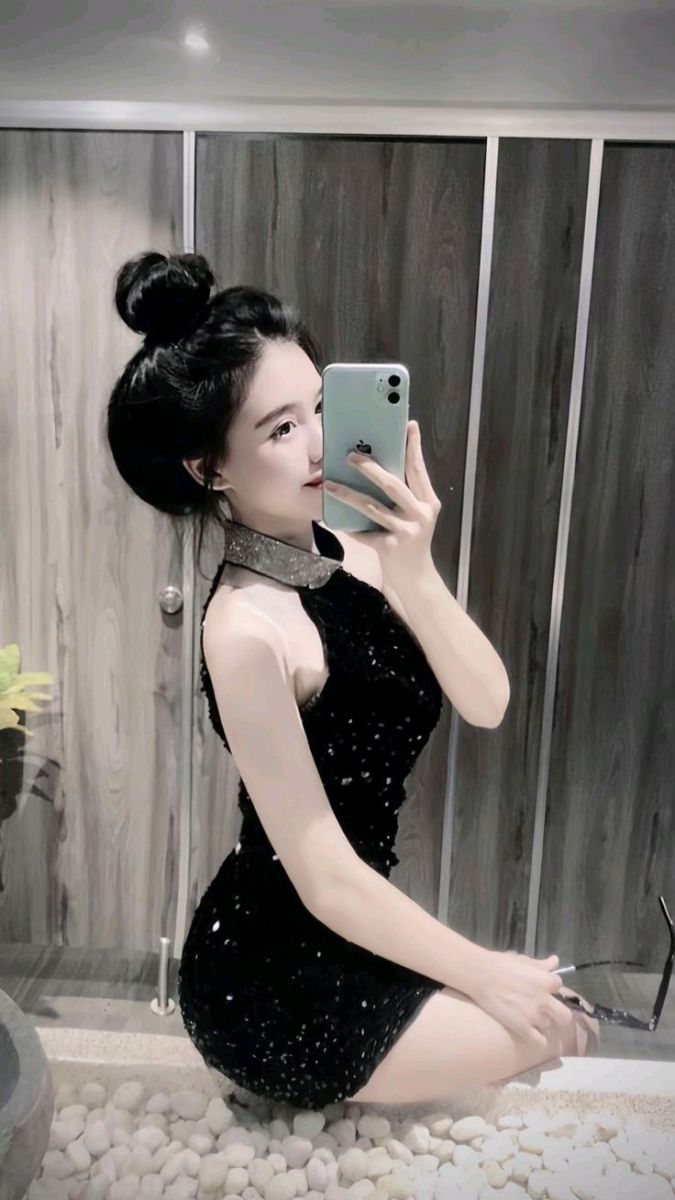 Cô gái trẻ xinh đẹp trong váy đen chụp ảnh selfie hiện đại
