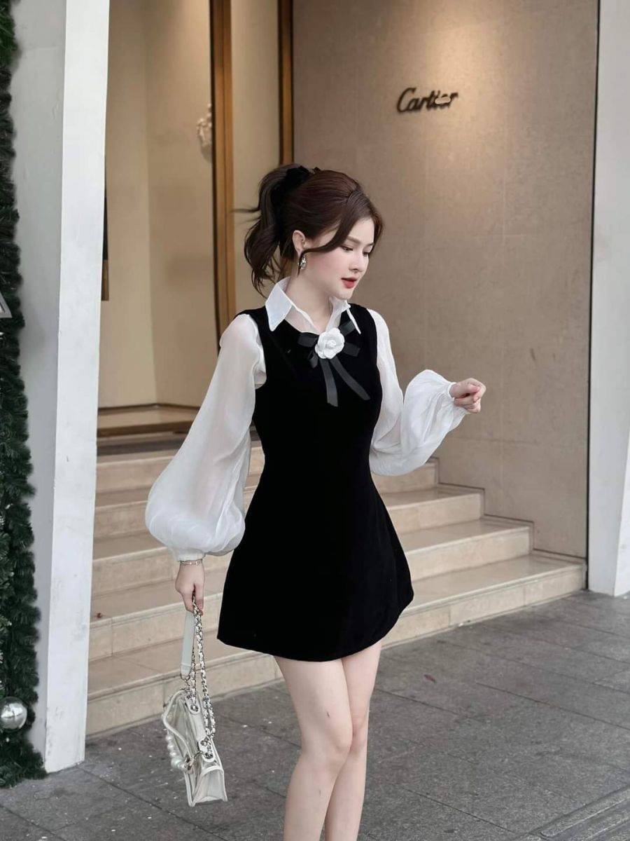 Cô gái trẻ xinh đẹp trong váy đen và áo trắng tại cửa hàng sang trọng