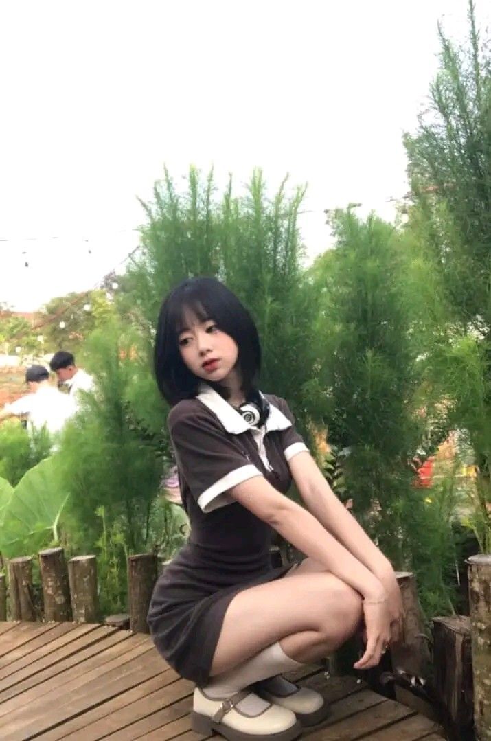 Cô gái trẻ xinh đẹp trong váy ngắn và áo trắng