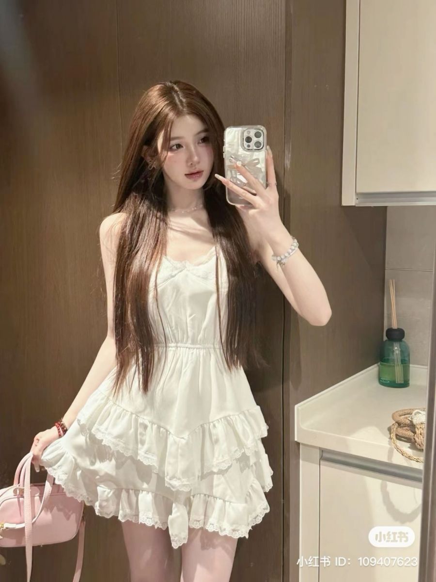 Cô gái trẻ xinh đẹp với đầm trắng xòe chụp selfie trong gương