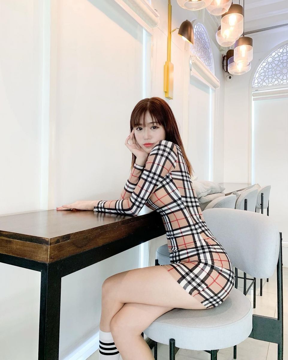 Cô gái xinh đẹp không mặc j ngồi bên bàn ghế uống cà phê