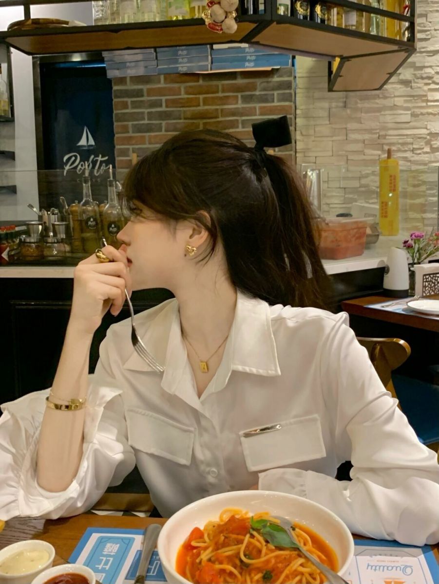 Cô gái xinh đẹp mặc áo trong suốt tại nhà hàng ấm cúng