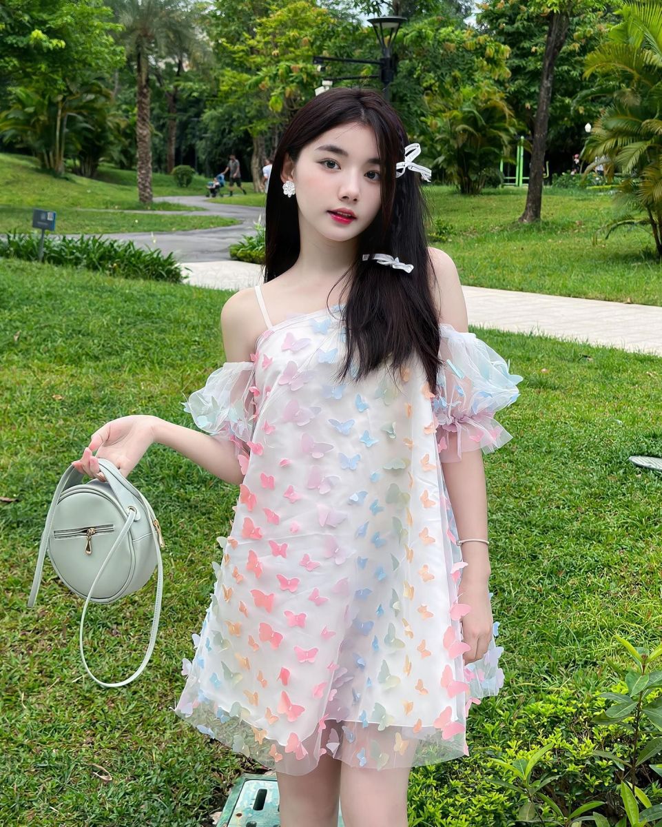 Cô gái xinh đẹp mặc đầm xuyên thấu giữa công viên xanh mát