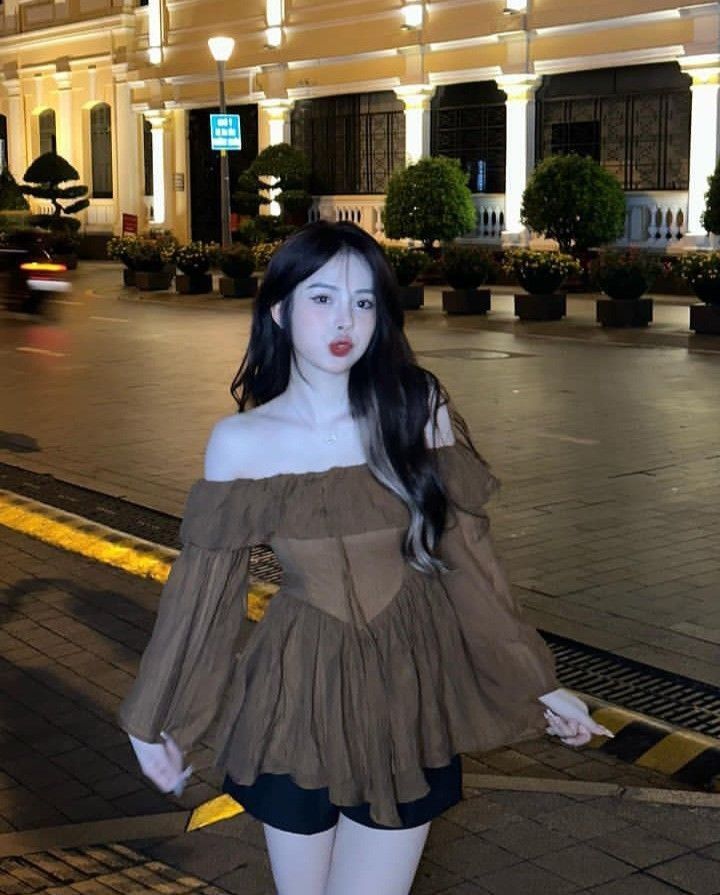 Cô gái xinh đẹp trong áo blouse màu nâu đi dạo phố