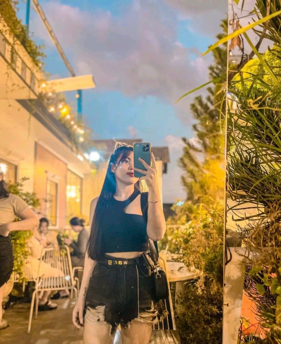 Cô gái xinh đẹp trong áo crop top đen và quần shorts