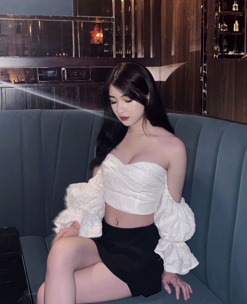 Cô gái xinh đẹp trong áo crop top trắng và chân váy đen