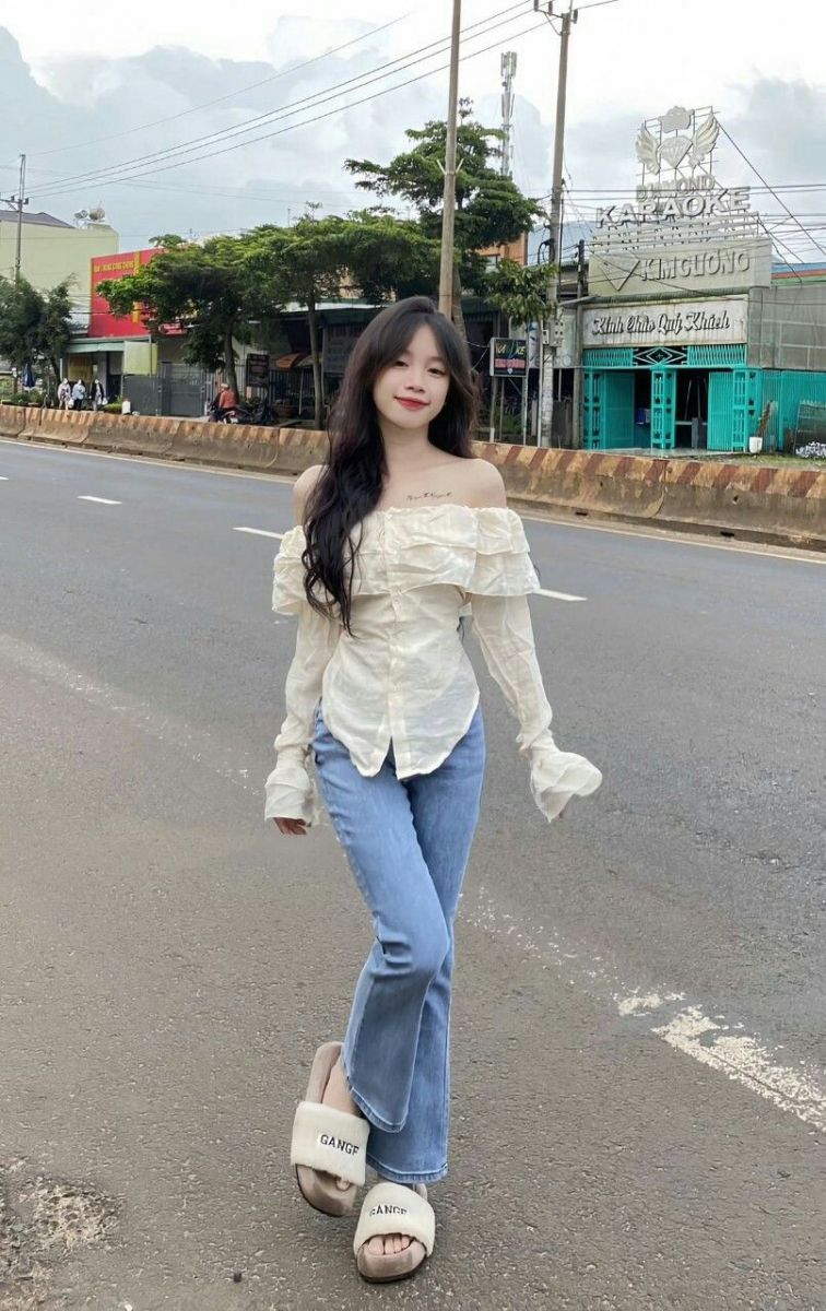 Cô gái xinh đẹp trong áo dài trắng và quần jeans xanh