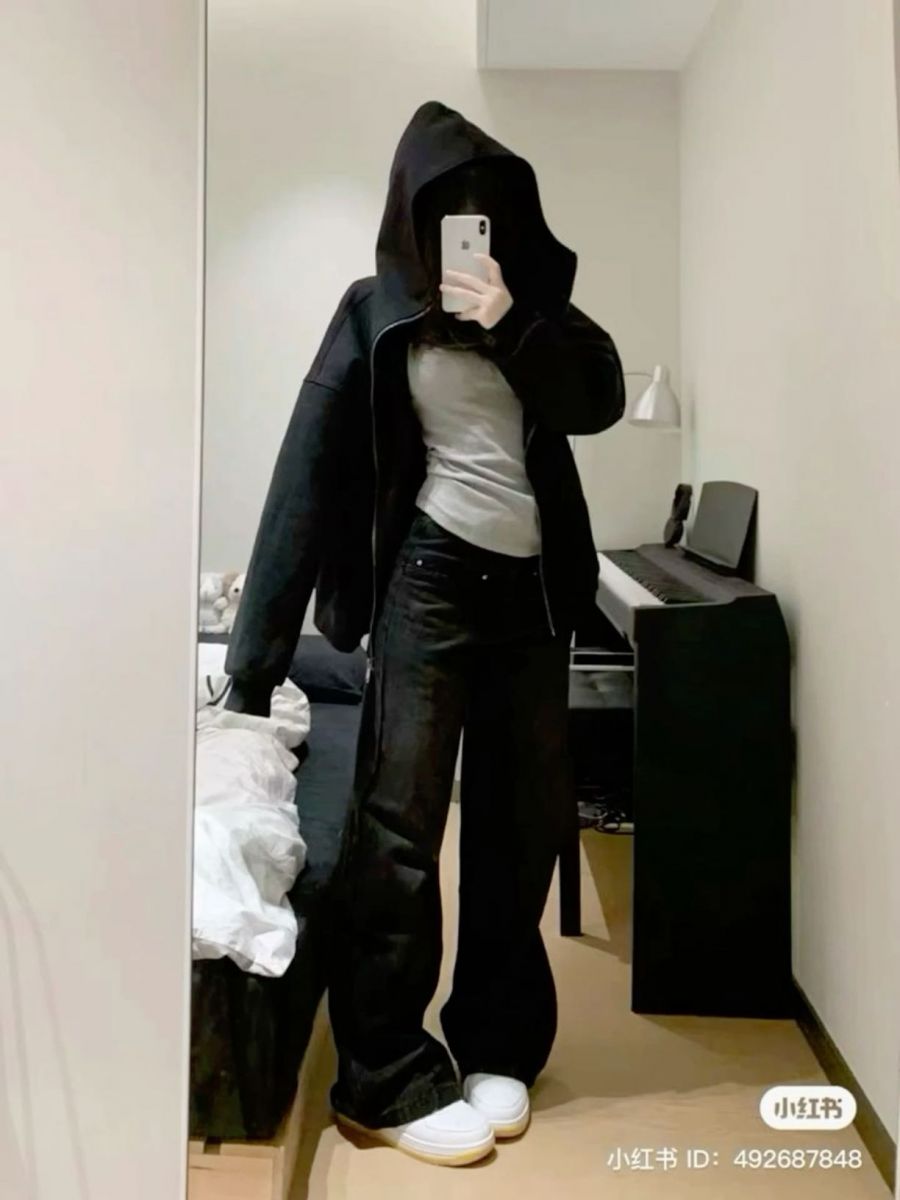 Cô gái xinh đẹp trong áo hoodie đen và quần jeans đen