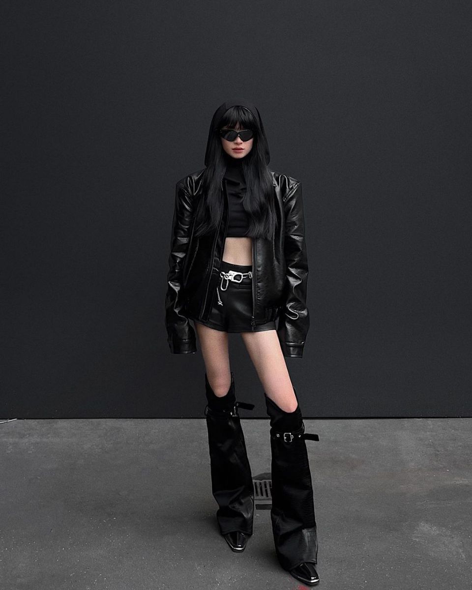 Cô gái xinh đẹp trong áo khoác da và crop top tự tin đi giày cao gót