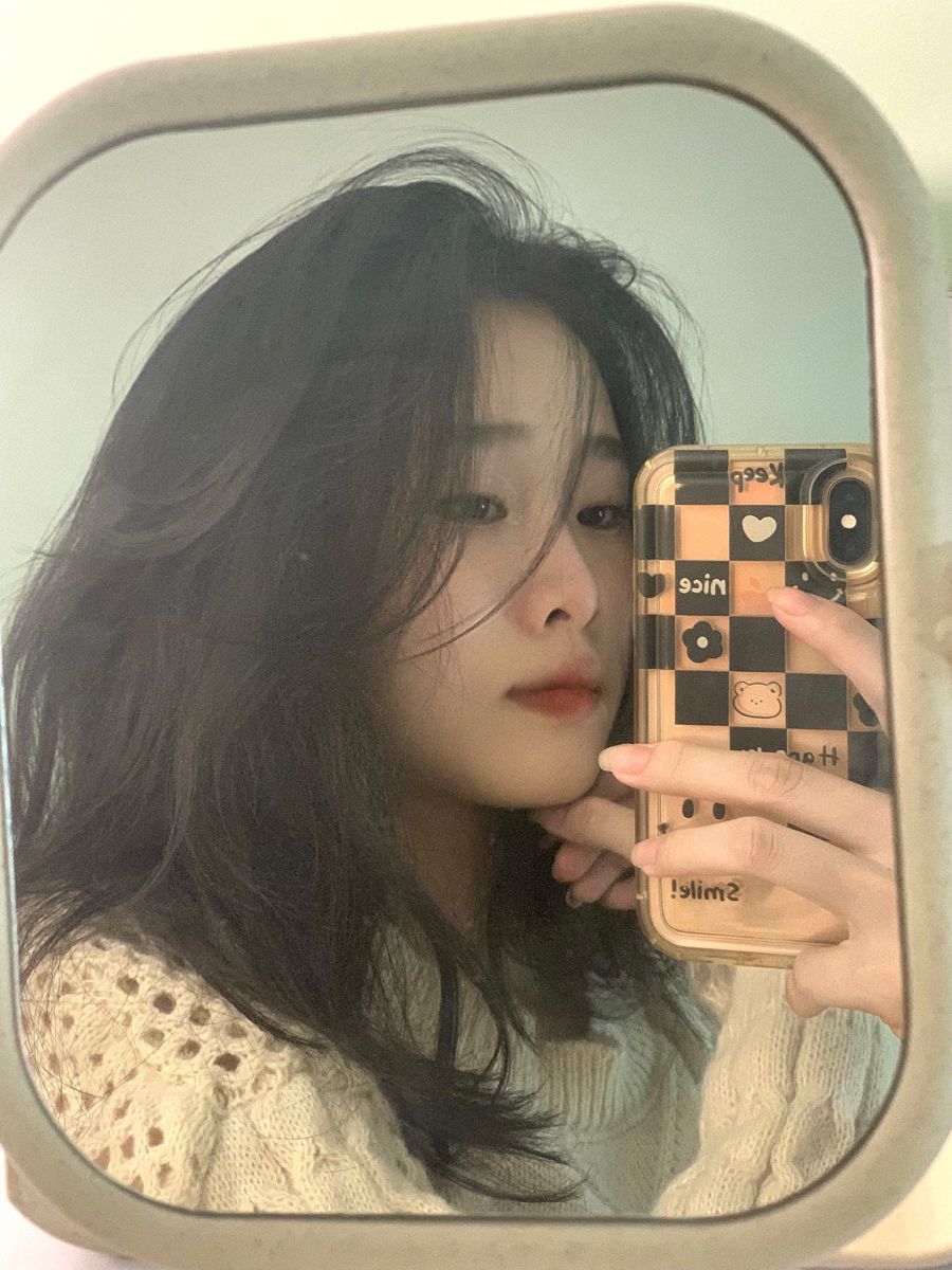Cô gái xinh đẹp trong áo len trắng chụp selfie dễ thương