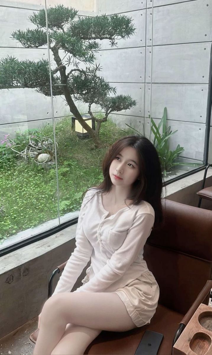 Cô gái xinh đẹp trong áo sơ mi trắng và quần shorts