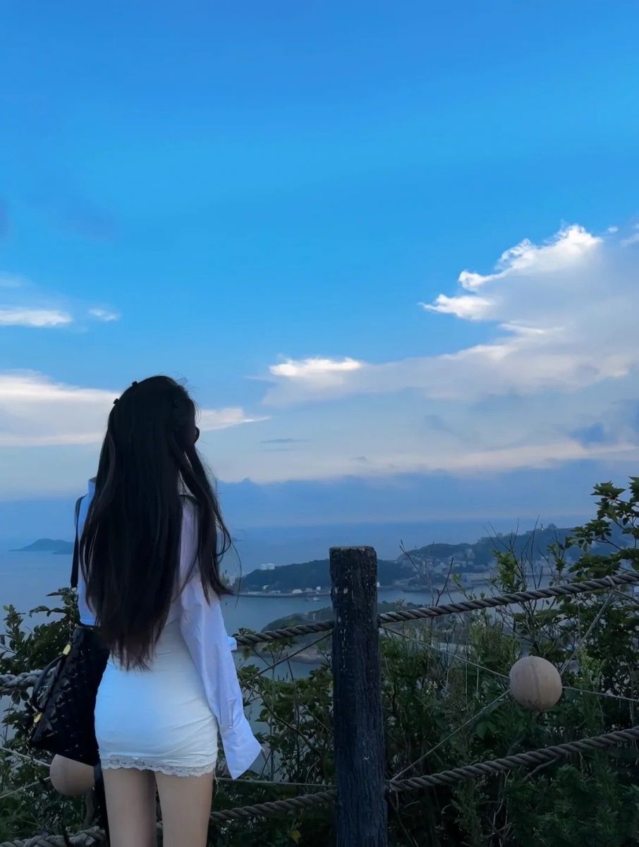 Cô gái xinh đẹp trong áo sơ mi trắng và váy ngắn bên biển