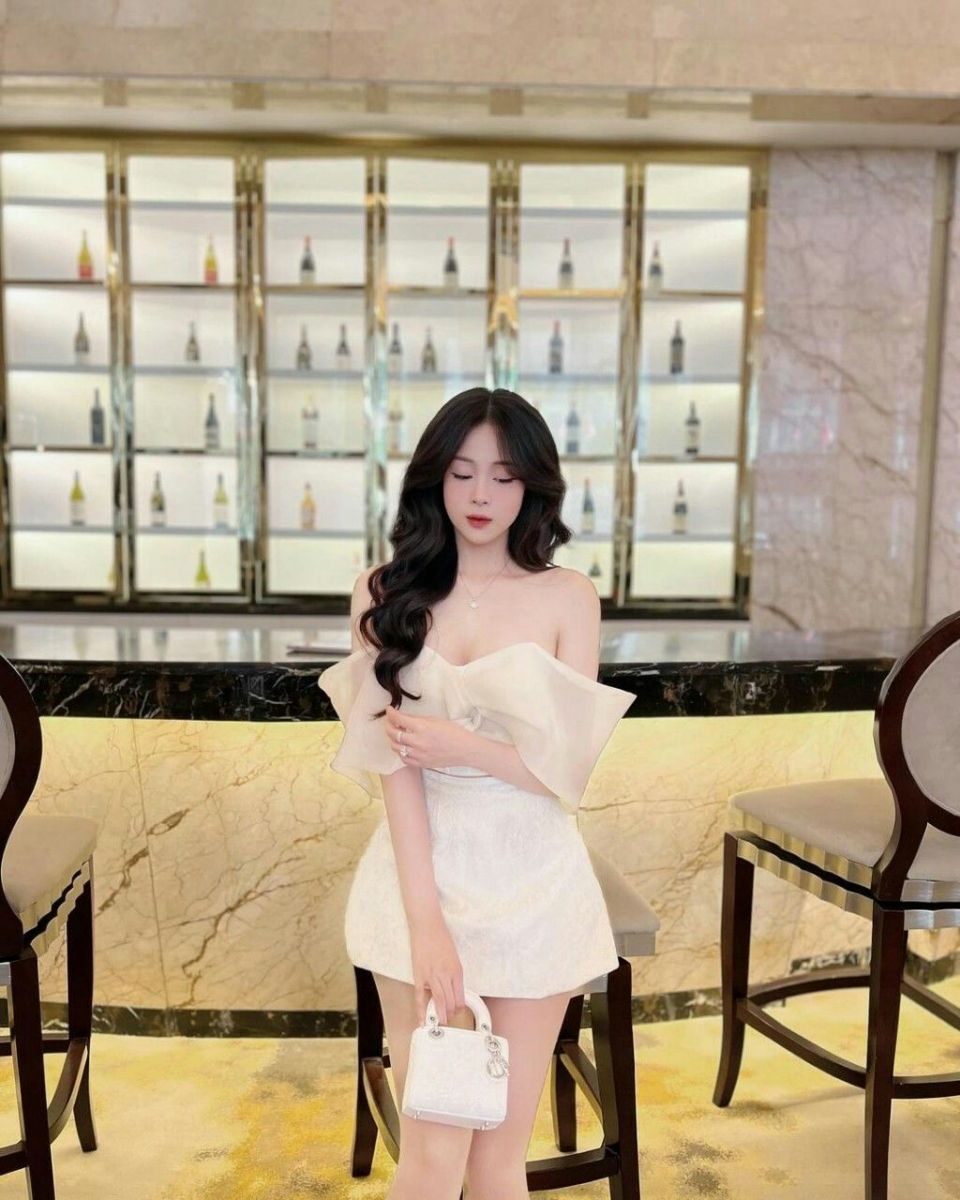 Cô gái xinh đẹp trong bar với túi xách nhỏ