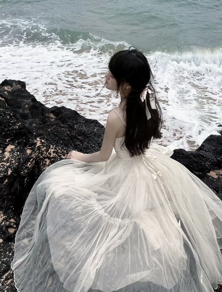 Cô gái xinh đẹp trong bộ đầm trắng bên bờ biển